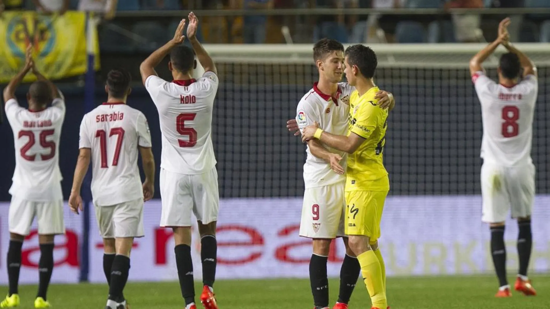 El delantero argentino del Sevilla, Luciano Vietto (3i), y el colombiano del Villarreal, Santos Borré, se saludan a la finalización del encuentro correspondiente a la segunda jornada de primera división, que han disputado esta noche en el estadio del Madrigal, en la localidad castellonense.