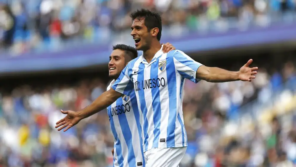 El delantero paraguayo del Málaga Roque Santa Cruz (d) celebra, junto al centrocampista chileno Pedro Morales, el gol, el primero de su equipo