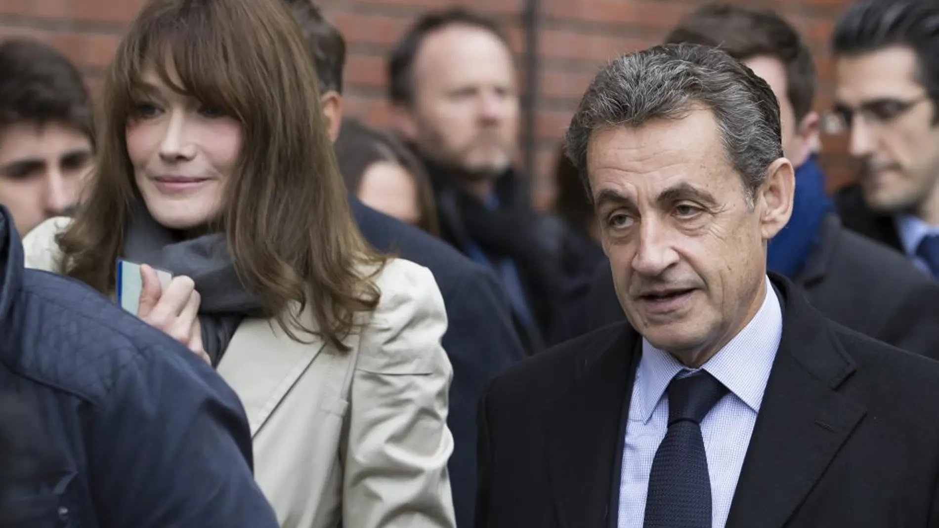 El expresidente francés Nicolás Sarkozy (i) y su esposa, Carla Bruni-Sarkozy, salen de un despacho de voto