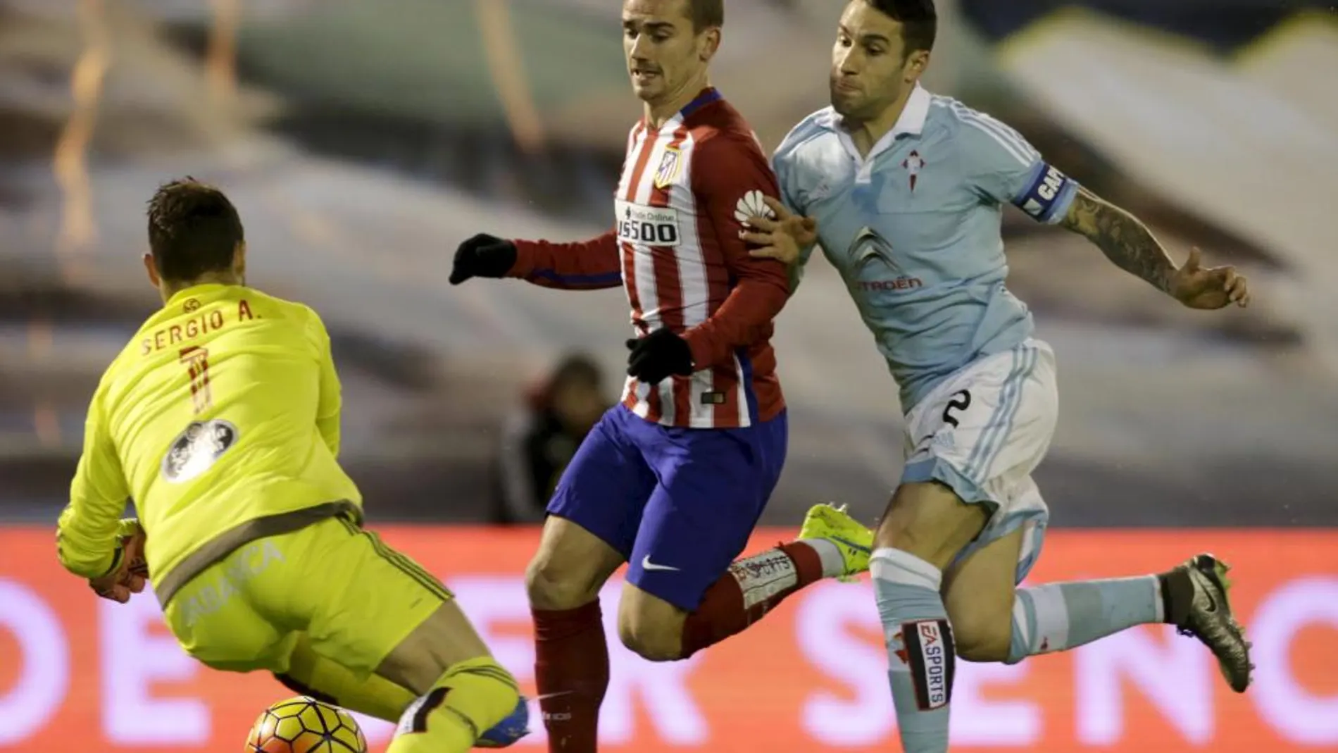 Hugo Mallo del Celta de Vigo (d) y Sergio Álvarez (i) en acción con Antoine Griezmann del Atlético de Madrid