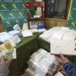 Dos agentes de la Unidad de Delincuencia Organizada Antidroga de la Guardia Civil muestran parte de los 130 kilos de cocaína y 230.000 euros incautados el pasado día 26 de febrero