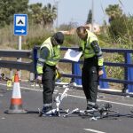 Agentes de las fuerzas de seguridad trabajan en el punto kilométrico 205 de la N-332 entre las localidades de Oliva y Denia tras el atropello de varios ciclistas