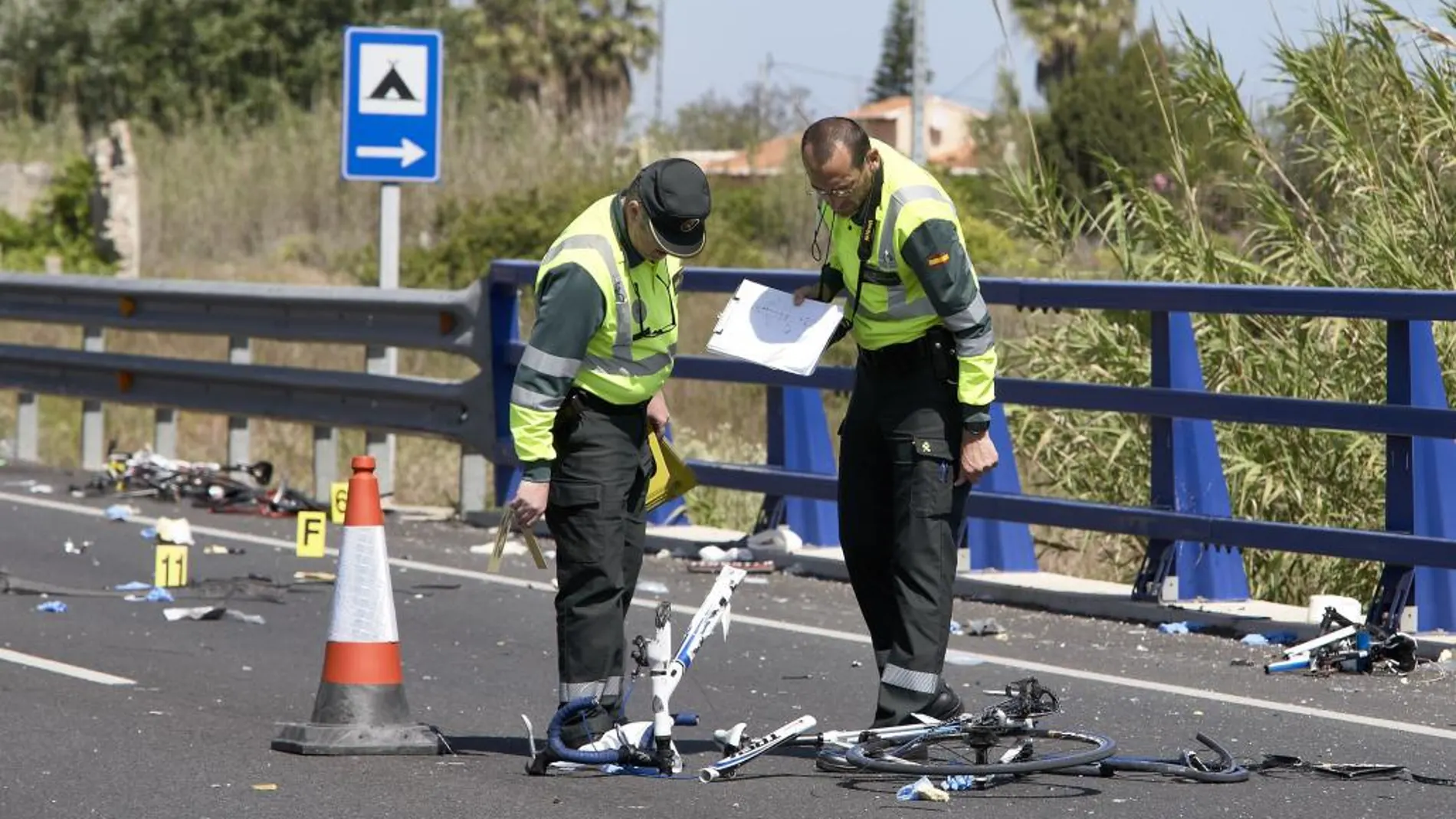 Agentes de las fuerzas de seguridad trabajan en el punto kilométrico 205 de la N-332 entre las localidades de Oliva y Denia tras el atropello de varios ciclistas