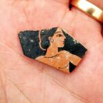 Fragnento de un trozo de cerámica decorada con la imagen de una figura en todos rojos, de unos 500 años a. de C.