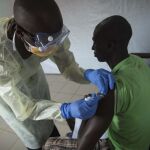 Un voluntario atiende a un paciente de ébola en Guinea