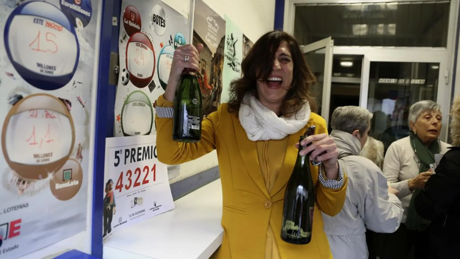 Una empleada de la administración número 30 de Zaragoza, en el barrio rural de Casetas, que ha repartido 900.000 euros del número 43.221, quinto premio de la Lotería Extraordinaria de Navidad, lo celebra con cava