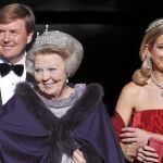 La reina Beatriz, con el príncipe Guillermo Alejandro y la princesa Máxima, ayer al abandonar el Palacio Real de Ámsterdam hacia la cena de gala