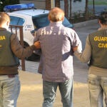 Dos agentes custodian a un detenido en una imagen de archivo