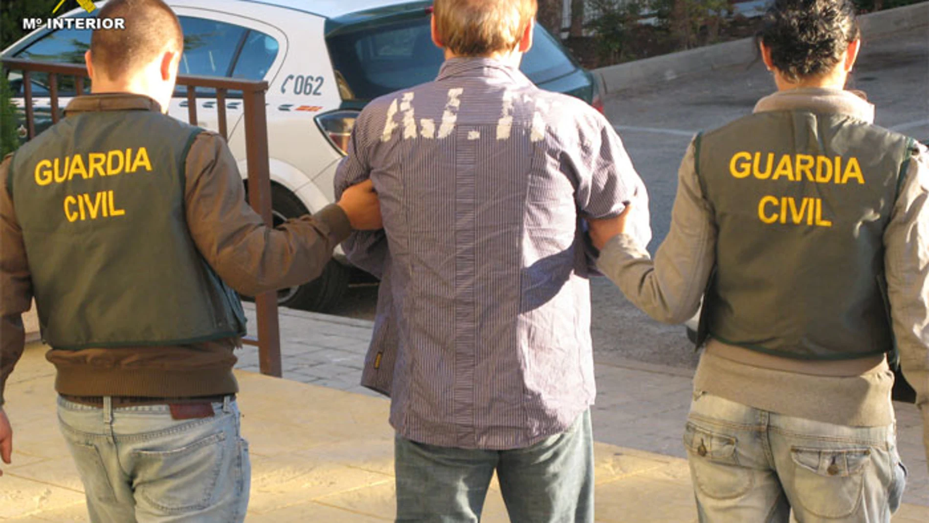 Dos agentes custodian a un detenido en una imagen de archivo