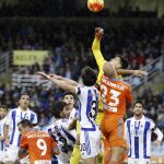 El portero de la Real Sociedad, el argentino Gerónimo Rulli (c), despeja el balón durante el partido ante el Valencia en San Sebastián