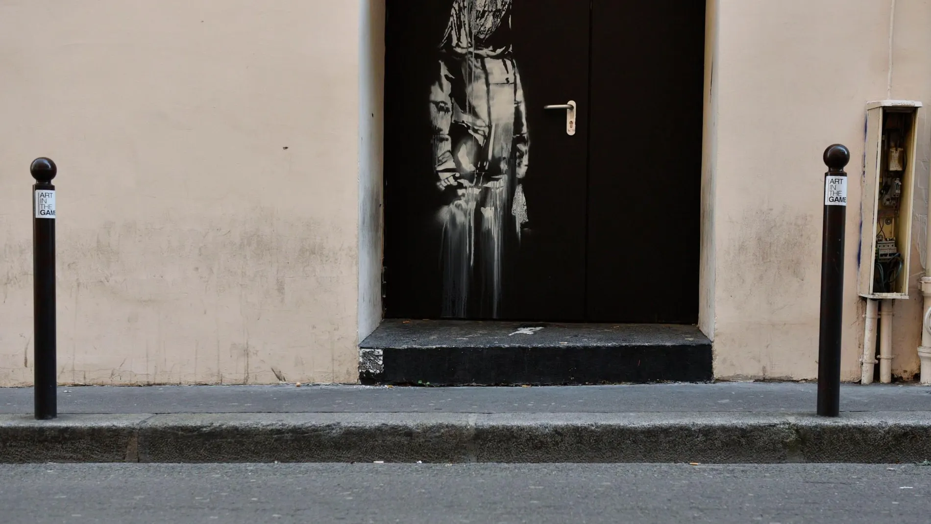Puerta de emergencia del teatro Bataclan con la obra de Banksy