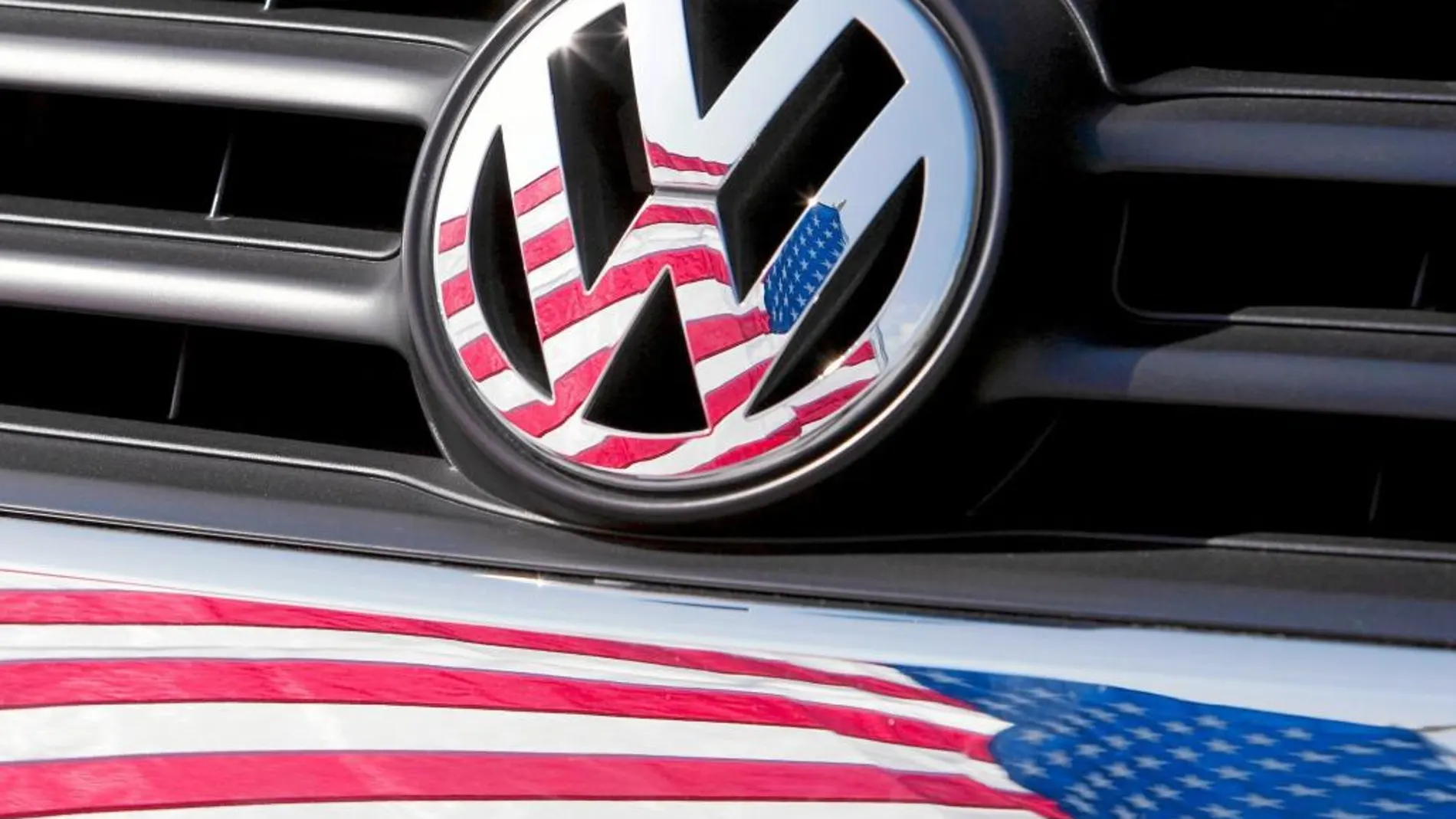 Una bandera de EE UU se refleja en el logotipo de Volkswagen