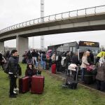 Los pasajeros esperan junto a la terminal para ser trasladados.
