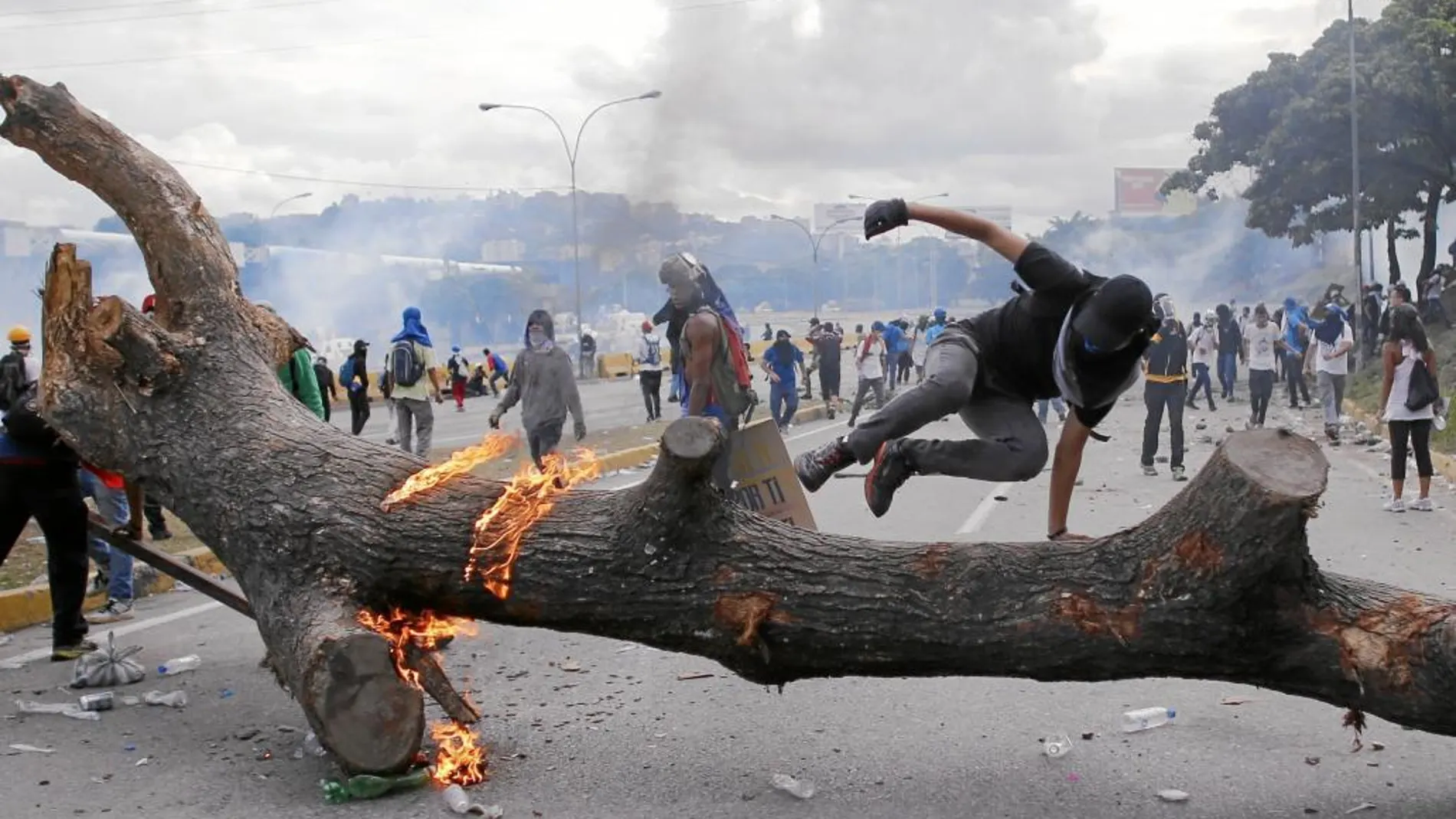 ESPIRAL DE VIOLENCIA. Manifestantes protestan contra el Gobierno en una calle cortada en Caracas, donde también se produjeron múltiples saqueos