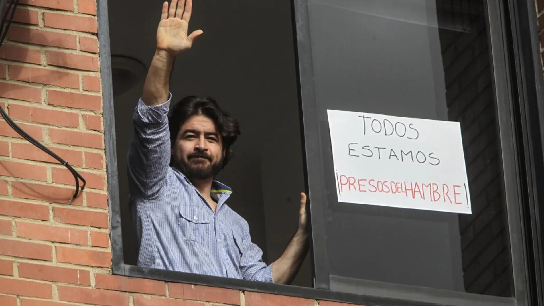 Fotografía de archivo del 7 de julio de 2016 del dirigente de Daniel Ceballos, saludando desde una ventana de la residencia donde cumplía casa por cárcel, en Caracas (Venezuela).