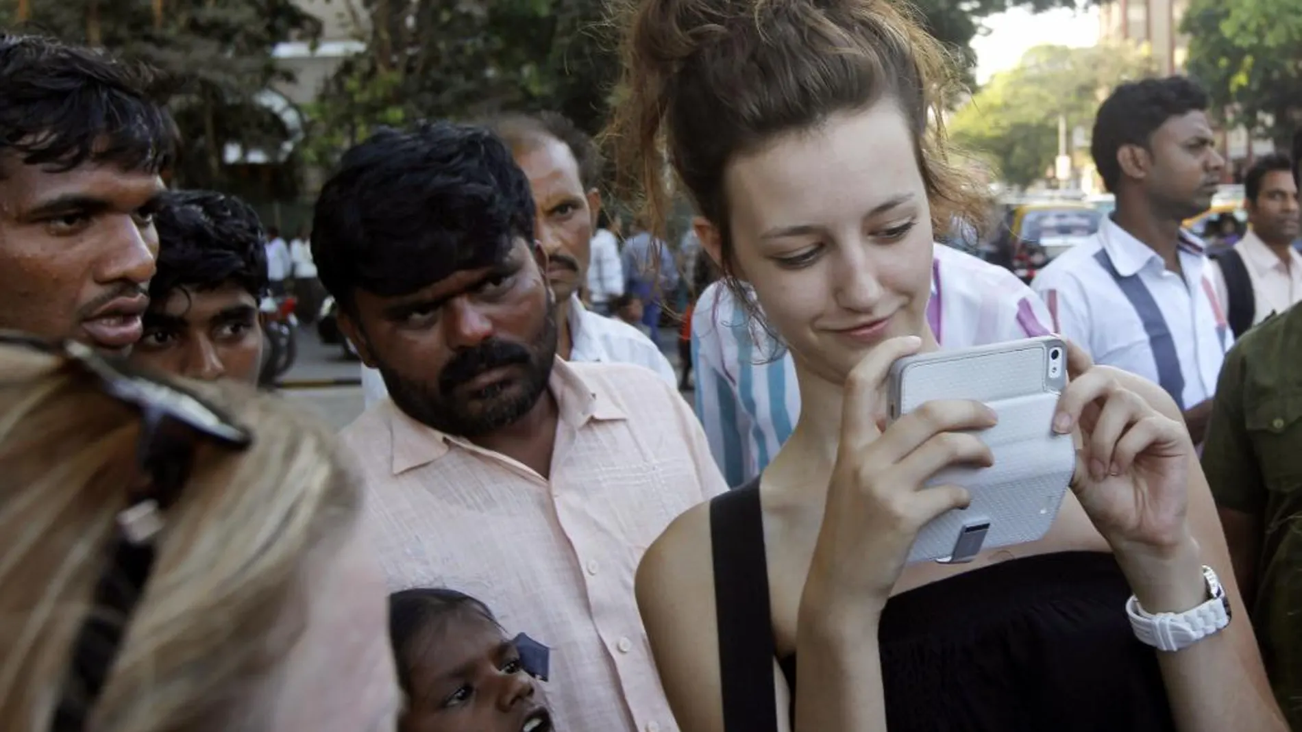 Una turista se fotografía con el móvil en una calle de Bombay