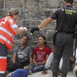 Agentes de la Guardia Civil y personal de Cruz Roja ayudan, a su llegada al puerto de Tarifa (Cádiz), a los 88 inmigrantes de origen subsahariano rescatados en la mañana del viernes