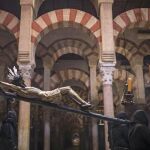 Devotos de la "Hermandad del Vía Crucis", procesionando dentro de la Mezquita-Catedral de Córdoba. EFE/Rafa Alcaide.