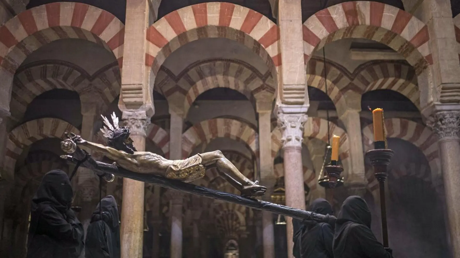 Devotos de la "Hermandad del Vía Crucis", procesionando dentro de la Mezquita-Catedral de Córdoba. EFE/Rafa Alcaide.