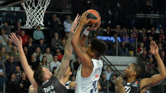 El jugador del Real Madrid Trey Thompkins (c) se dirige a la cesta ante Daniel Theis (i) del Brose Bamberg