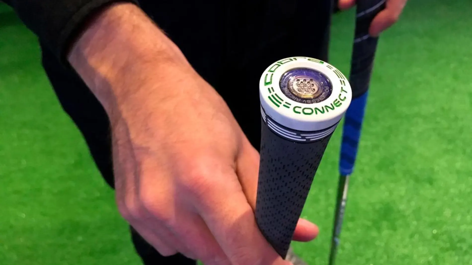 Una persona enseña un palo de golf con un sensor desde donde se capta todo tipo de datos relevantes para determinar la estrategia que debe seguir el jugador / Efe