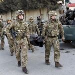 Policías británicos sacan el cuerpo de un a de las víctimas del atentado junto a la embajada española en Kabul.