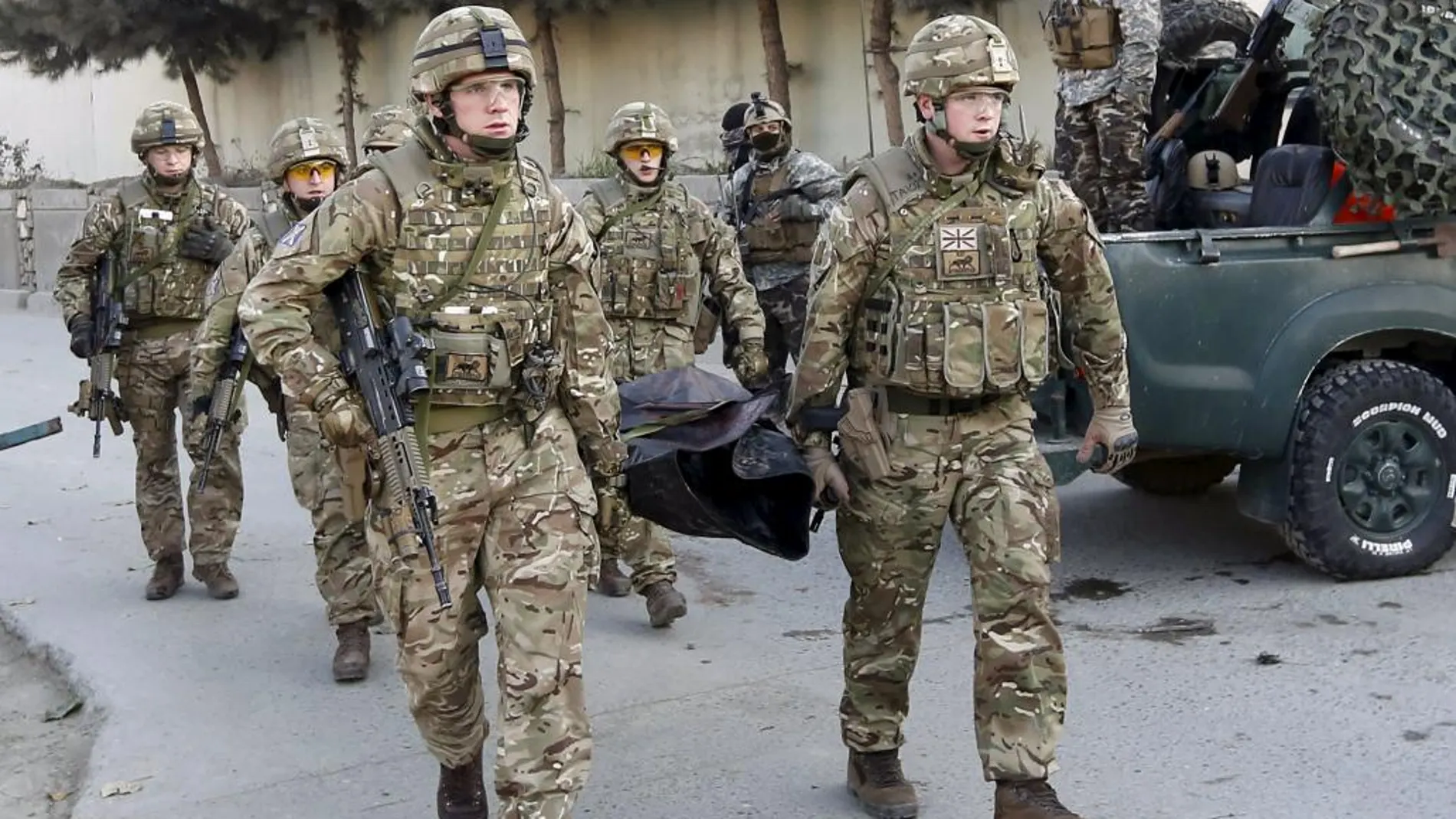 Policías británicos sacan el cuerpo de un a de las víctimas del atentado junto a la embajada española en Kabul.