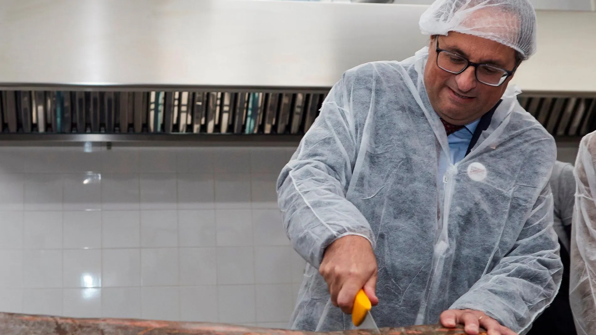 Quim Torra, se dispone a cortar una enorme calabaza durante la visita a la empresa social Espigoladors/Efe