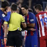 El árbitor Gil Manzano, tras mostrar la cartulina amarilla a Luis Suárez que le protesta la tarjeta