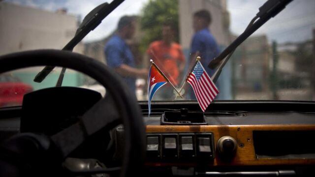 Interior de un coche en La Habana, en el que se ven la bandera de EUU y la de Cuba