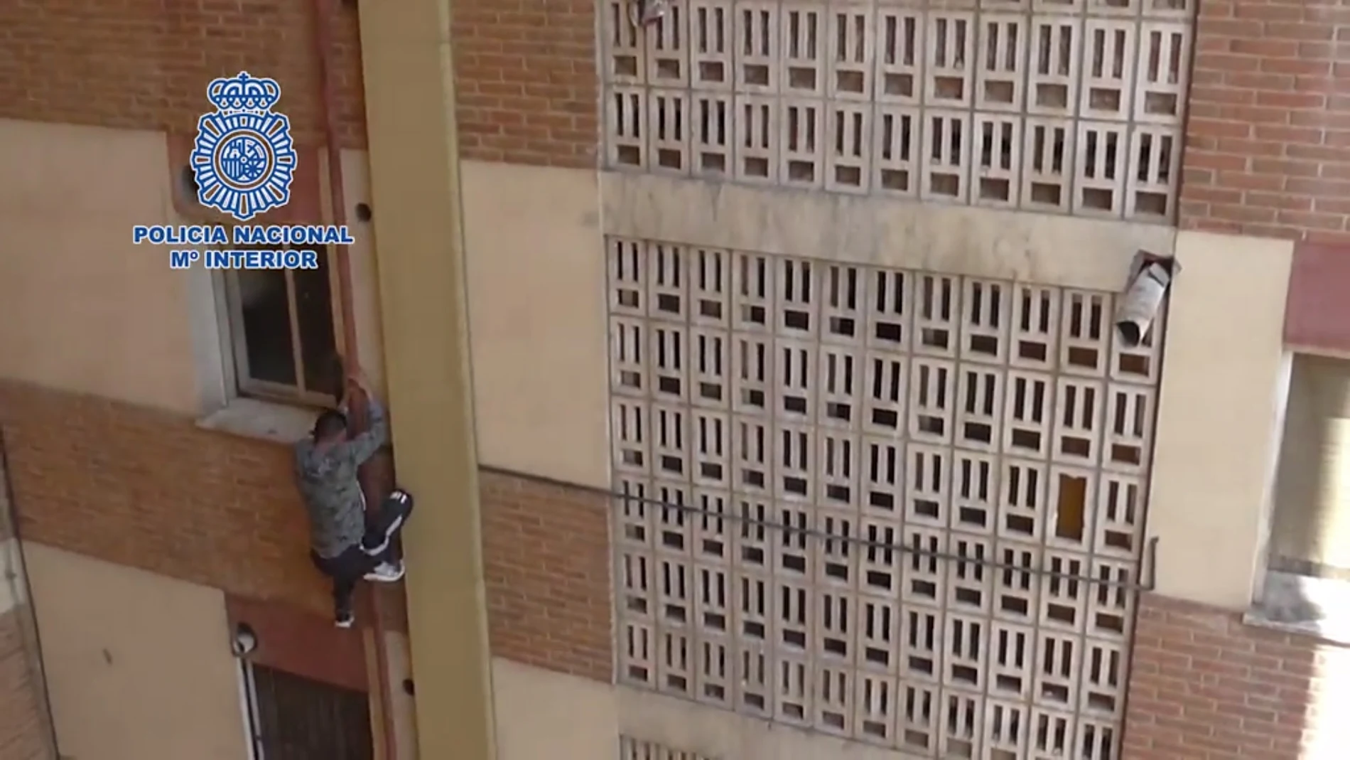 Momento en el que uno de los detenidos en Murcia intentó huir agarrándose a una de las tuberías de la fachada