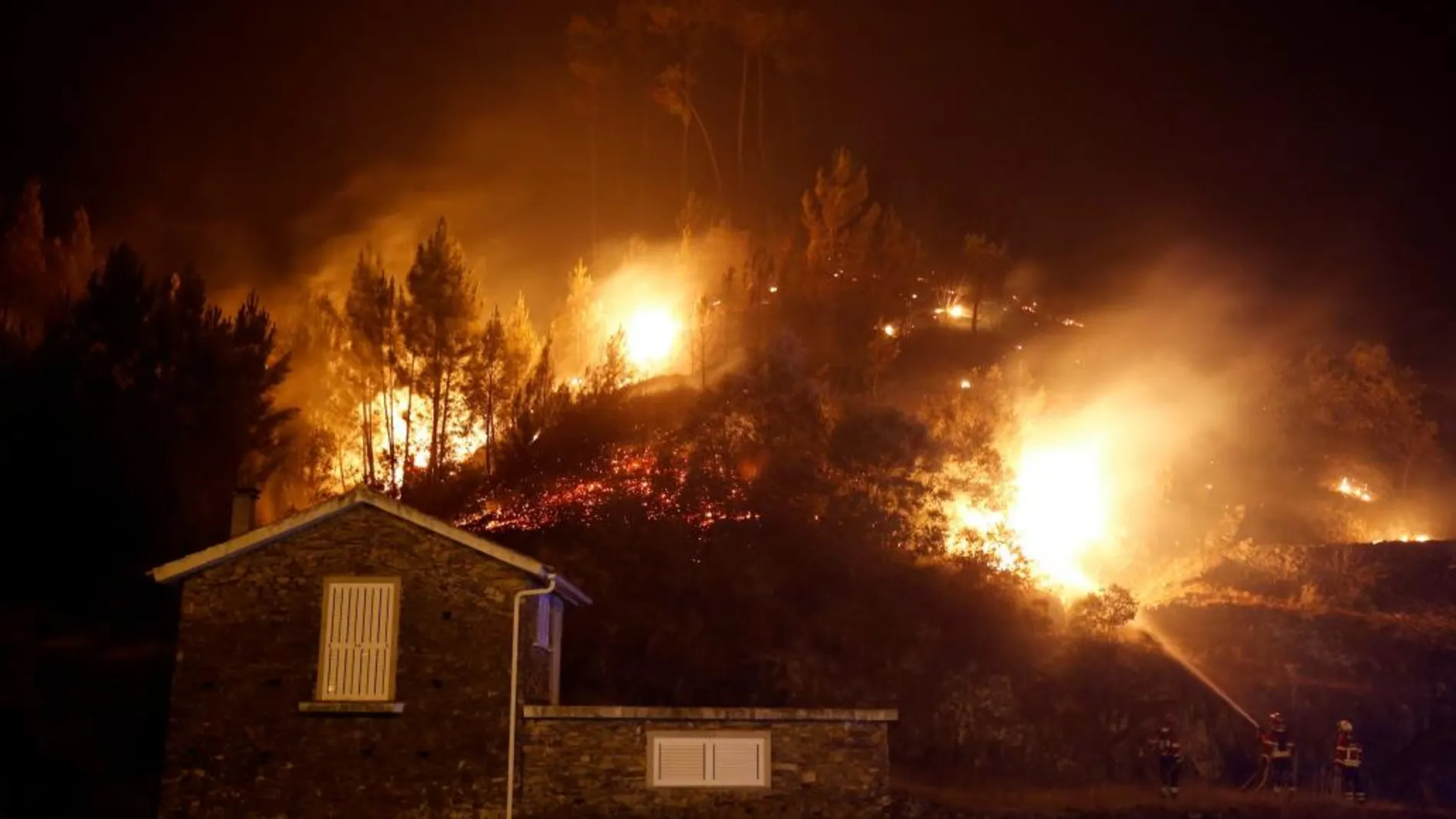 Los bomberos trabajan para evitar que el fuego devore una casa en Carvalho