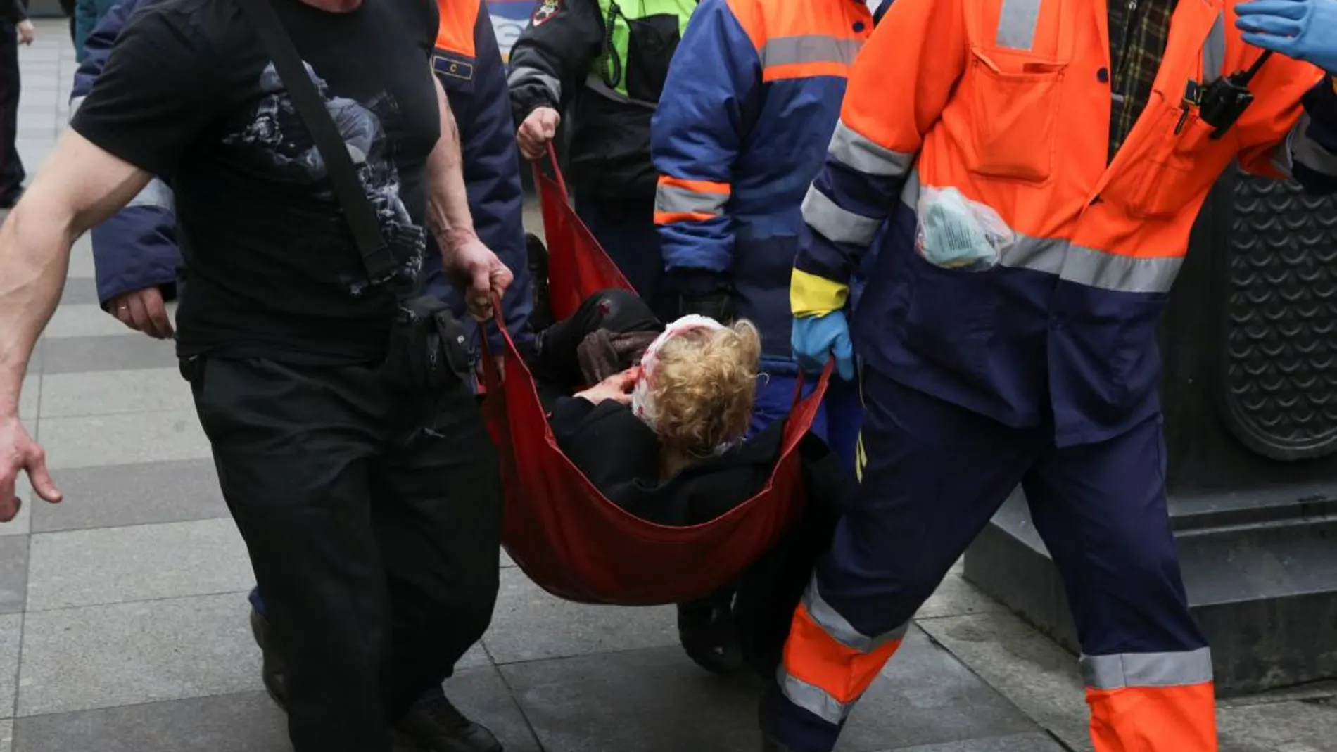 Trabajadores de los servicios de emergencia trasladan a una herida del atentado del metro de San Petersburgo