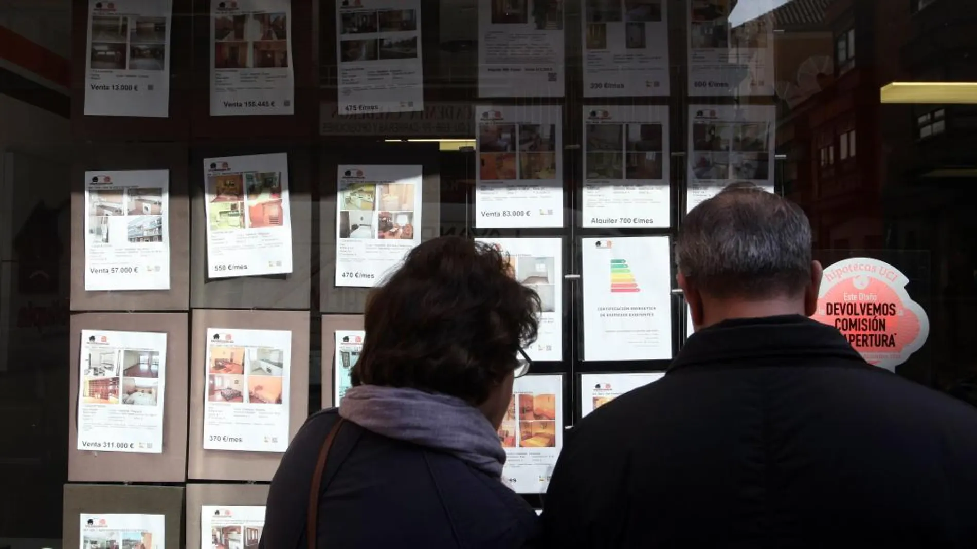 Una pareja mira los anuncios de una inmobiliaria en Valladolid en plena subida de precios