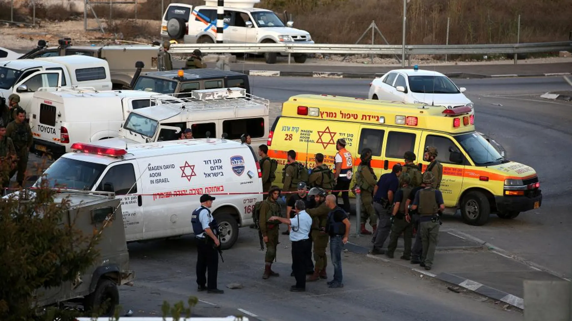 Policías y soldados israelíes inspeccionan la zona en que ha tenido lugar el atropello.