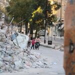 Varios niños juegan con una bicicleta entre las ruinas de Alepo