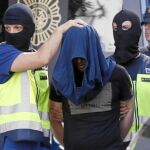Uno de los yihadistas detenidos ayer en Madrid, en el momento de ser trasladado al furgón policial