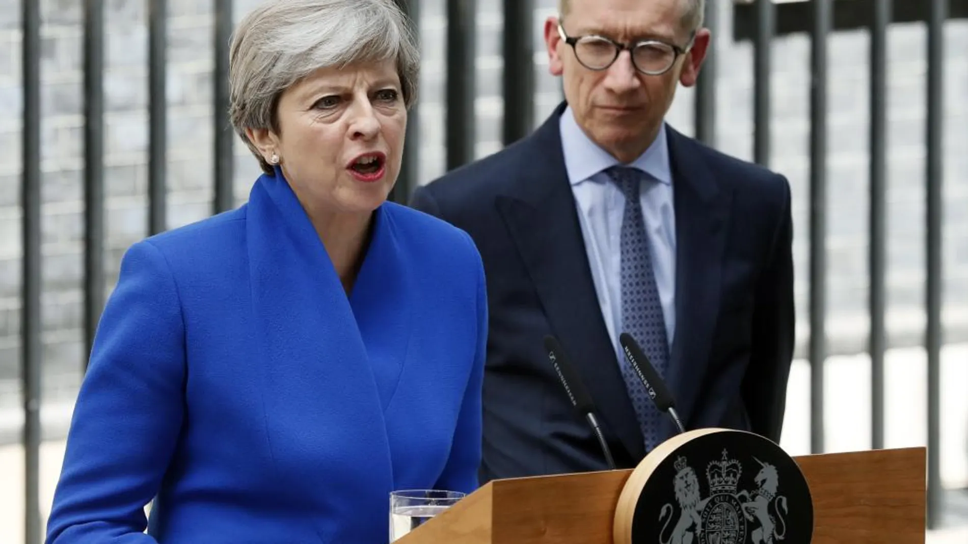 La primera ministra británica, Theresa May (i), ofrece una rueda de prensa junto a su marido, Philip (d), en el número 10 de Downing Street tras reunirse con la reina Isabel II