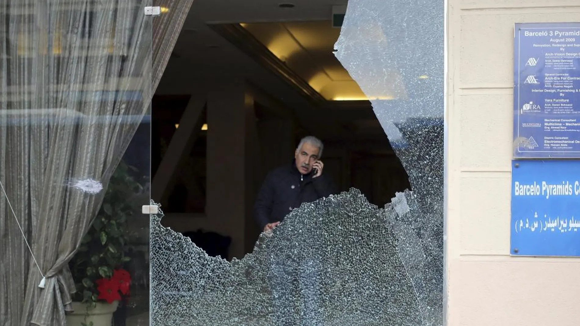 Un policía en el interior del hotel con los cristales destrozados tras el tiroteo