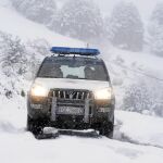 Un coche de la Guardia Civil patrulla por las carreteras nevadas