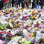 Varias personas contemplan las flores colocadas como homenaje a las víctimas del atentado islamista, cerca del puente de Londres, ayer