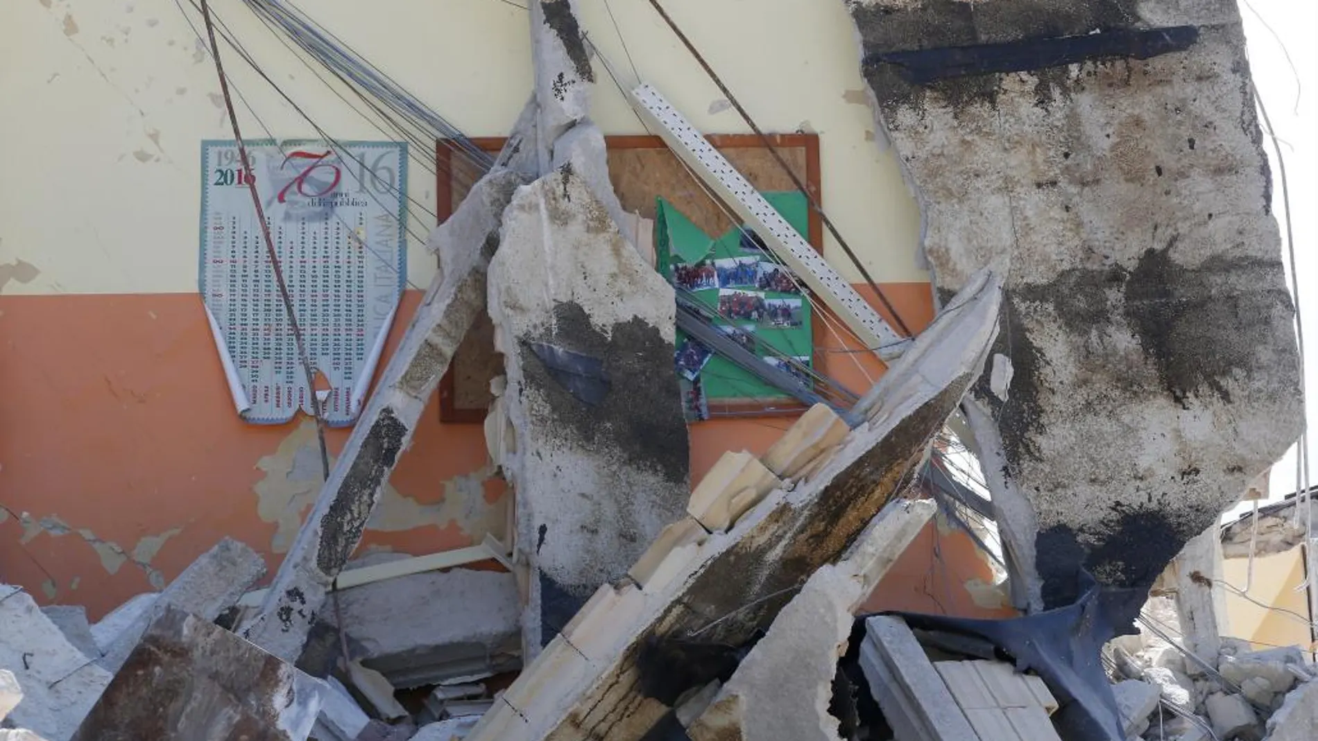 Un calendario y un panel con fotos en la destruída escuela de Amatrice