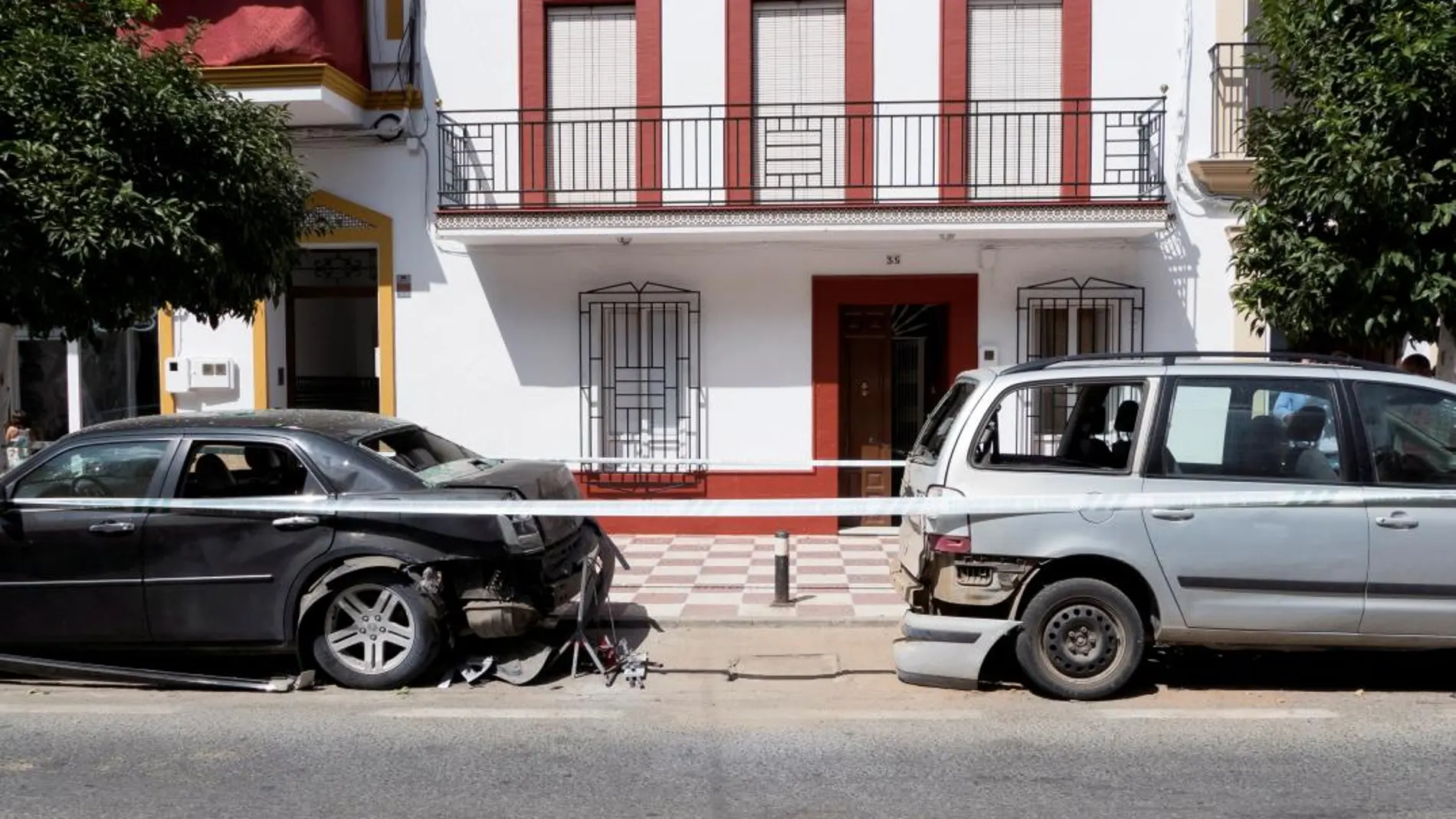Dos de los cuatro coches estacionados en la Avenida de la Soledad, en la localidad sevillana de Cantillana (Foto: Efe)