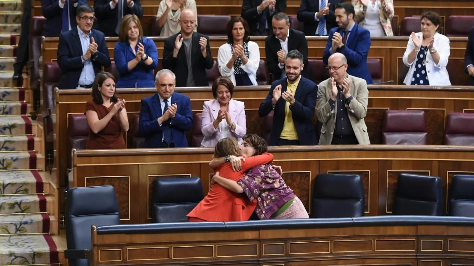 La ministra de Justicia, Dolores Delgado (i), recibe el apoyo de la ministra de Hacienda, María Jesús Montero (d) y de la bancada socialista durante el pleno del Congreso de los Diputados. Foto: Efe