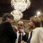 El presidente de la Generalitat, Carles Puigdemont, conversa con la presidenta del Parlament, Carme Forcadell, y el portavoz de JxS, Jordi Turull (c).