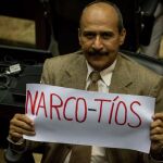 El diputado de la Asamblea Nacional (AN) por la coalición opositora Mesa de Unidad Democrática (MUD) Luis Silva sostiene un cartel que dice "Narco-Tios"