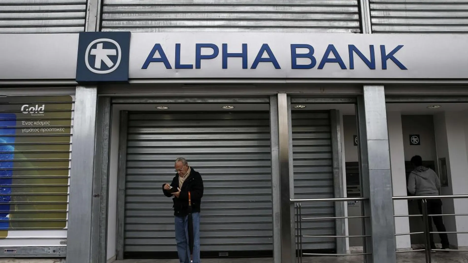 Un hombre, a las puertas de una sede de Alpha Bank.