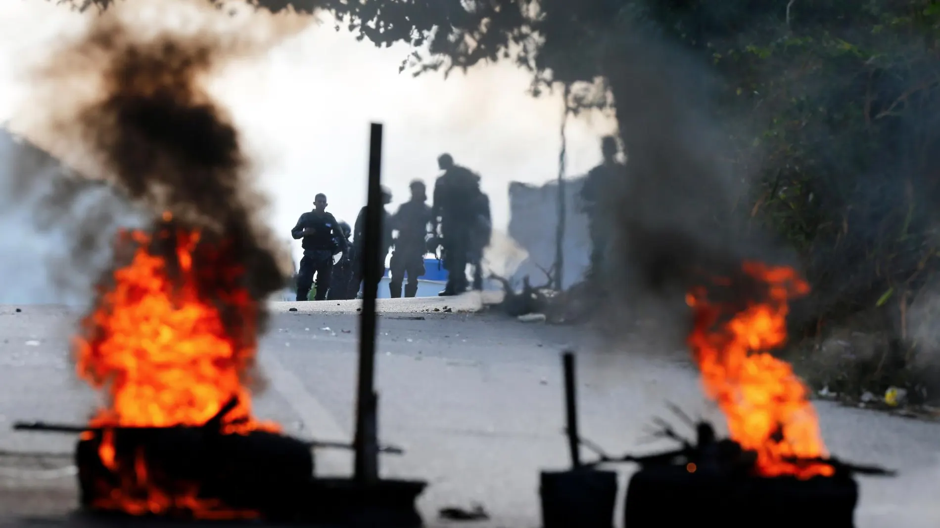 Guardias Bolivarianos permanecen a distancia de una de las barricadas levantada por los manifestantes contrarios al régimen de Maduro