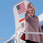 Hillary Clinton saluda al subir a su avión rumbo a Carolina del Norte, al retomar su campaña