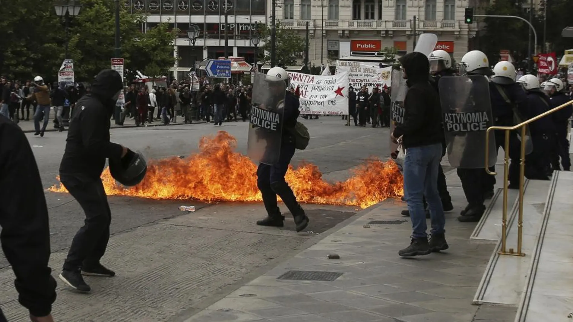 Varios manifestantes se enfrentan a la policía antidisturbios durante una protesta organizada en la plaza Syntagma en el marco de la huelga general de 24 hora